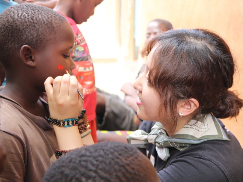 Raise Volunteer painting child's face on Christmas